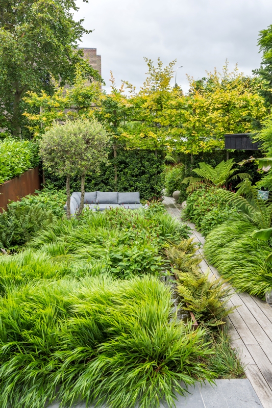 Tuininspiratie: speelse tuin met veel groen en kleurrijke borders.